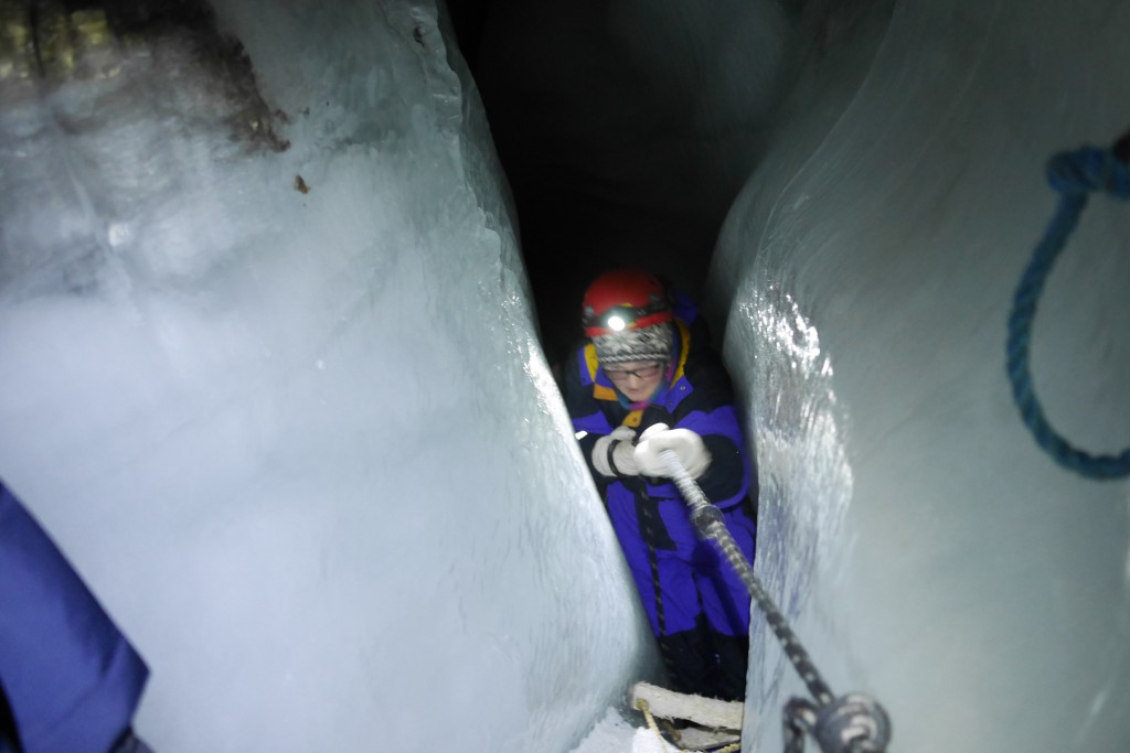 Mette klatrer opp en av de åletrange trappene ned i isgrotta. Foto: Carina Alice Bredesen